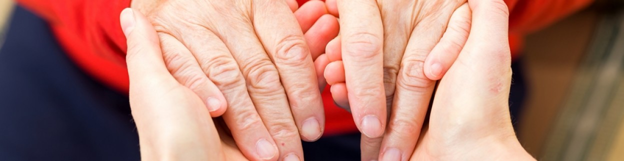 Rodzic trzyma dziecko za ręce w hospicjum.